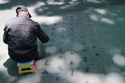 Rear view of man standing on footpath