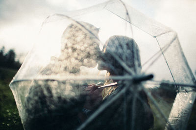 Close-up of woman seen through glass