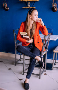 A young woman holds a stack of books. teaching a student according to textbooks. 