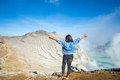 Rear view of man standing on rock