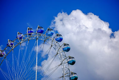 Low angle view of ferris wheel against blue sky