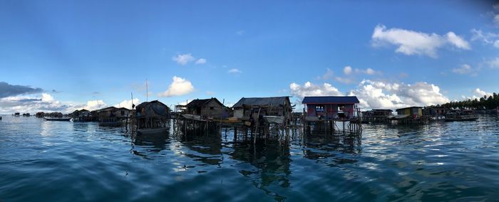 Panoramic view of buildings by sea against sky