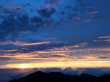 Low angle view of silhouette mountains against dramatic sky