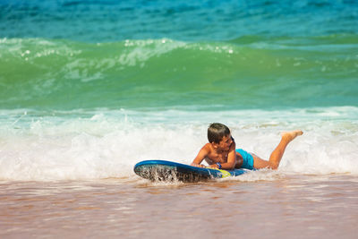 Young man surfing in sea