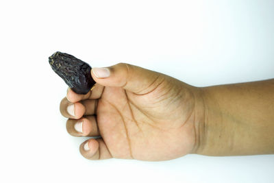 Close-up of man holding hands over white background