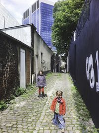 People walking on footpath amidst buildings