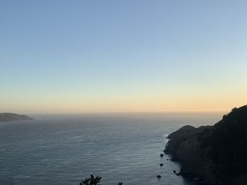 Scenic view of sea against clear sky at sunset