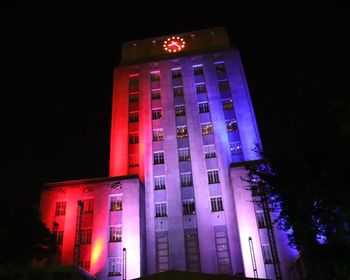 Low angle view of illuminated building against sky at night