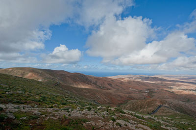 Scenic view of mountains against cloudy sky