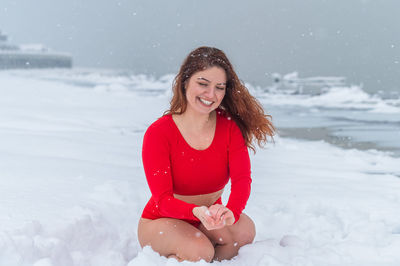 Portrait of young woman standing on snow