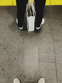 Low section of people standing on tiled floor