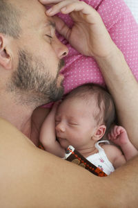 Father sleeping with newborn girl