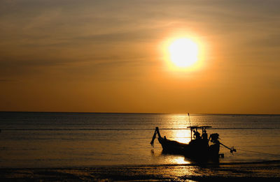 Silhouette boat in sea against sky during sunset