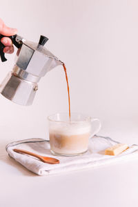 Cropped image of hand pouring coffee in cup