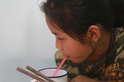 Close-up of girl drinking juice in cup