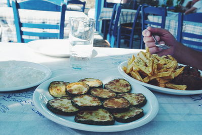 Cropped image of hand holding fork over food