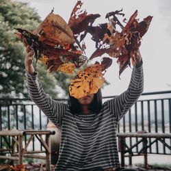 Midsection of man holding autumn leaves