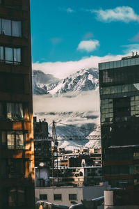 View of buildings in city against cloudy sky