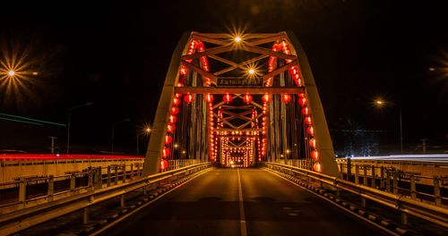 Illuminated bridge against sky at night