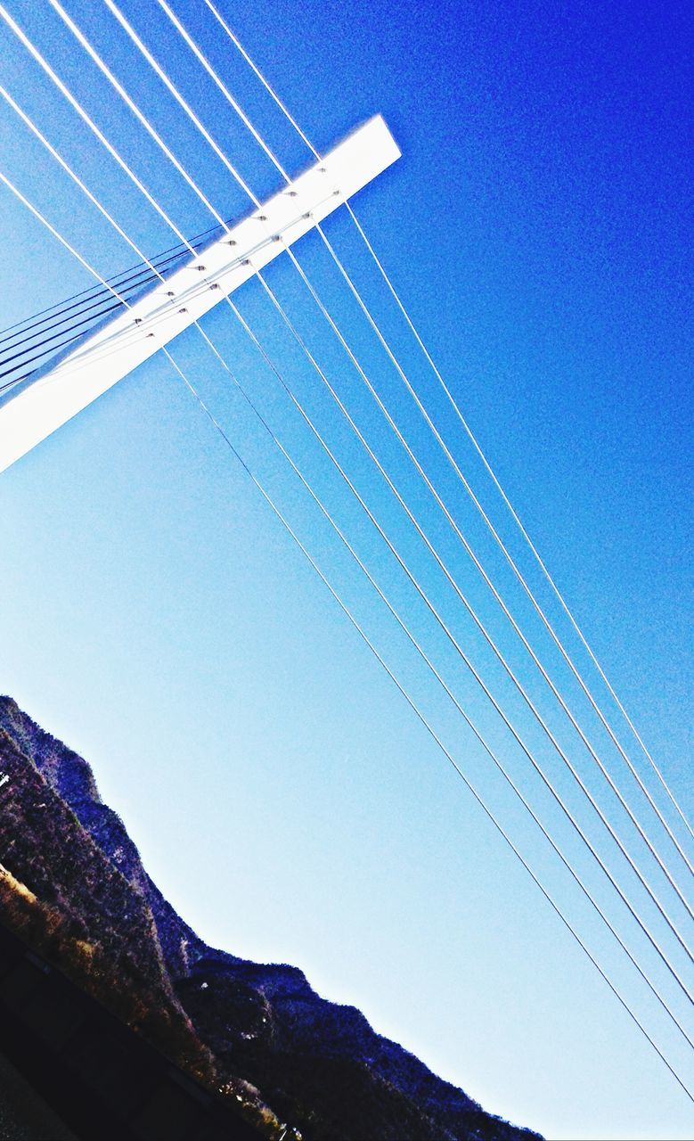 blue, clear sky, low angle view, built structure, vapor trail, architecture, building exterior, transportation, city, connection, copy space, outdoors, day, travel, sky, tall - high, no people, modern, skyscraper, travel destinations