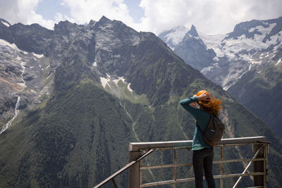Full length of man standing on railing against mountains