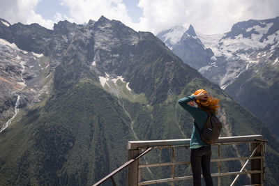 Woman looking at mountains while standing on observation point