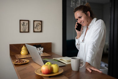 Cheerful businesswoman answering phone call