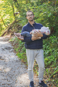 Full length of young man standing in forest