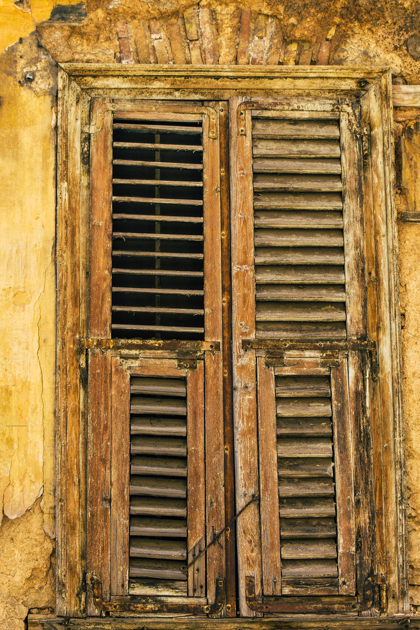 FULL FRAME SHOT OF WEATHERED WINDOW ON OLD BUILDING