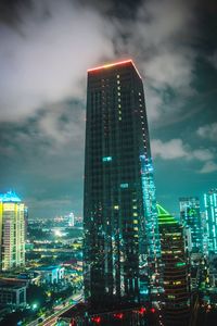 Illuminated buildings in city against sky