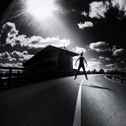 Silhouette of woman walking on road