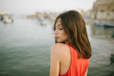 Portrait of woman standing against water