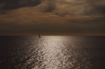 Scenic view of sea against cloudy sky at sunset