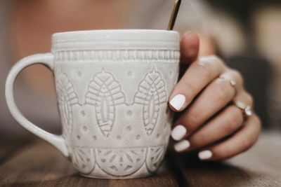 Close-up of hand holding coffee cup