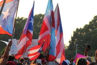 People holding flags during protest against sky
