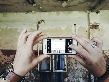 Cropped image of woman photographing through smart phone