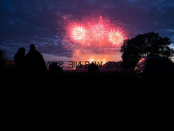 Silhouette people at music concert against sky at night