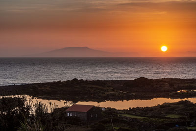 Scenic view of sea against orange sky