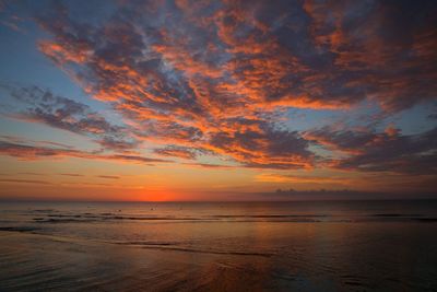 Scenic view of sea against dramatic sky during sunset