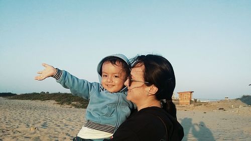 Portrait of mother and son standing on beach