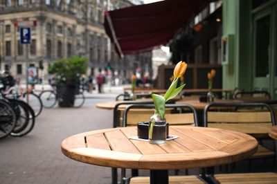 Empty chairs and table at sidewalk cafe