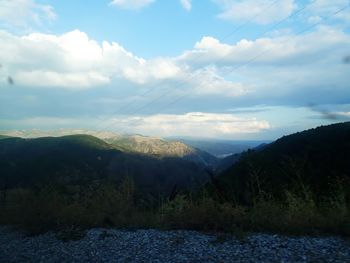 Scenic view of mountains against cloudy sky