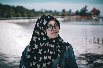 Portrait of woman standing by water