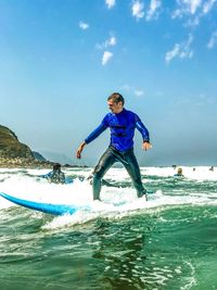 Man surfing in sea against sky