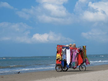 People on beach by sea against sky