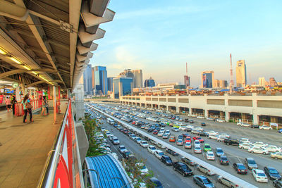 Panoramic view of railroad station platform in city against sky