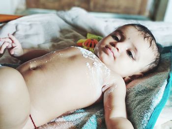 Baby lying on bed at home