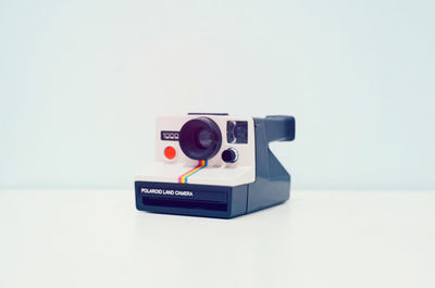 Close-up of camera on table against white background