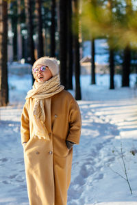 Woman standing on snow covered tree