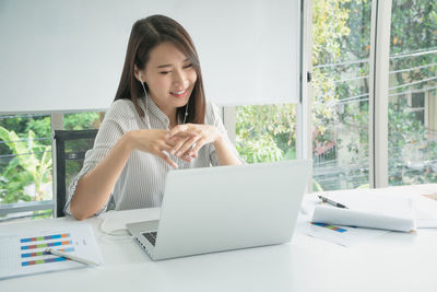 Young woman using phone on table